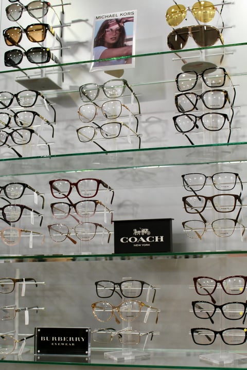 Optical eyeglass display with multiple shelves showing designer frames